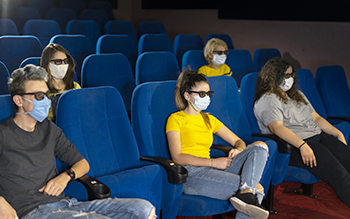 Group of people in the theaters with covid-19 safety regulations. 